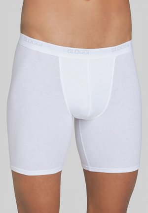 Boxer brevi Sloggi bianchi con una texture liscia, cintura elastica con il nome del marchio e un design di lunghezza a metà coscia.