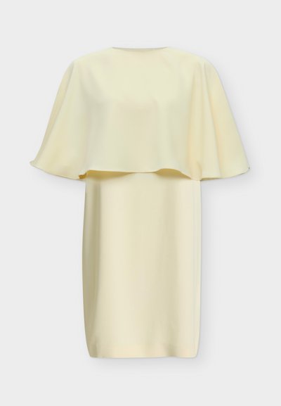 Robe crème mi-longue avec une cape ample qui s'étend sur les épaules et le haut des bras, avec un col rond.