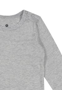 Hellgraues Babyshirt mit langen Ärmeln, rundem Halsausschnitt und zwei Druckknöpfen an der Schulter für ein einfaches Ankleiden.