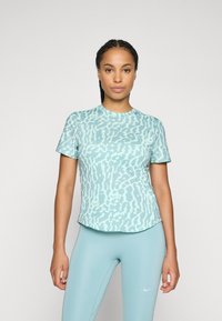Cămașă scurtă mint green cu imprimeu subtil de leopard. Fabricată dintr-un material neted, cu tiv rotunjit și decolteu rotund.