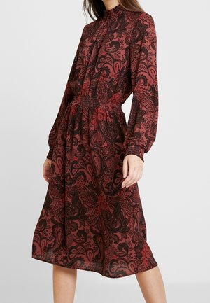 Rode jurk met paisleypatroon, lange mouwen, een hoge halslijn en een gathering in de taille. Gemaakt van lichtgewicht stof, valt hij onder de knie.