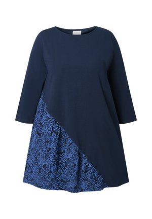 Marineblauwe jurk met driekwartmouwen, met een asymmetrisch ontwerp en een gemusterde blauwe stofpaneel aan de onderkant links.