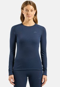 Navy long-sleeve base layer top made of ribbed fabric, featuring a rounded neckline and logo on the left chest, with fitted silhouette and flat seams.