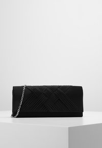 Černé psaníčko z hladké tkaniny s tkanou texturou a řetízkovým popruhem. Obdélníkový tvar se zapínáním na klopu.