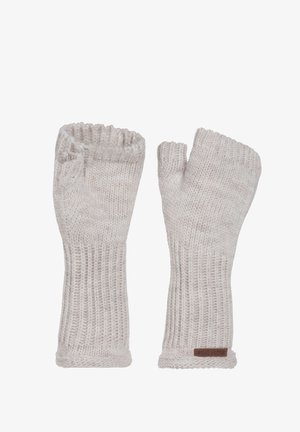 Gebreide vingerloze handschoenen in lichtbeige, met ribbeltextuur, elastische manchet en een klein leren label op één handschoen.