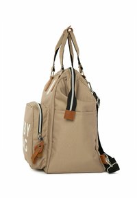 Beige canvas tas met zwart-witte banden, met ritszakken en bruinaccenten. Heeft de tekst "Baby Bag" en meerdere opbergcompartimenten.