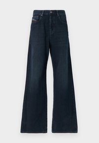 Τζιν παντελόνια με φαρδιά μπάτσα σε σκούρο denim, με μέση μέσου ύψους, μπροστινές τσέπες, λεπτές ραβδώσεις και καθαρό τελείωμα. Διαθέτουν μεταλλικό κούμπωμα κουμπιού.