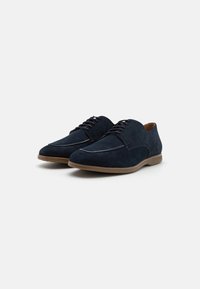 Pantofi din suede bleumarin, cu vârful ascuțit, design cu șireturi și talpă din cauciuc, având un accent subtil de bej de-a lungul marginii.