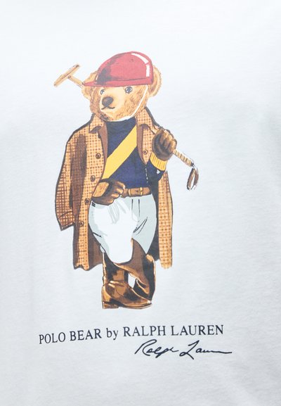 Αρκούδα ντυμένη με ενδυμασία πόλο, φορώντας κράνος, γάντια, μπ ότες και τζάκετ, κρατώντας ένα ρόπαλο πόλο, με το κείμενο «Polo Bear by Ralph Lauren» από κάτω.