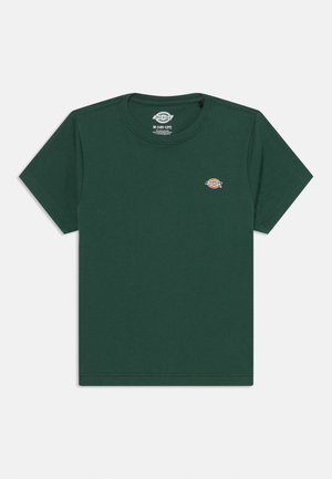 T-shirt de algodão verde escuro com decote redondo, mangas curtas e um pequeno logótipo bordado no lado esquerdo do peito. Design simples sem padrões.