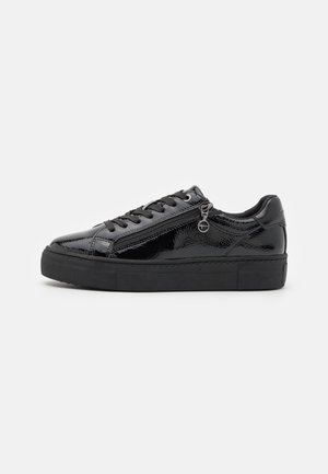 Black patent leather sneaker with a textured finish, round toe, flat rubber sole, and a zippered side detail. Features black laces.