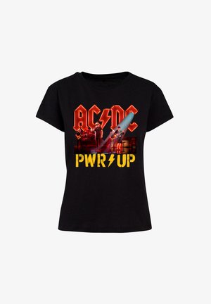 Melna kokvilnas t-kreklu ar grafisku apdruku, kurā redzams "AC/DC" sarkans un "PWR UP" dzeltenā krāsā, kopā ar attēliem no grupas dalībniekiem un instrumentiem.