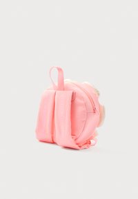 Kleine roze rugzak met een ronde vorm, voorzien van een voorste ritszak en zachte stofriemen. De tekst "BILLIEBLUSH" is zichtbaar op de riemen.