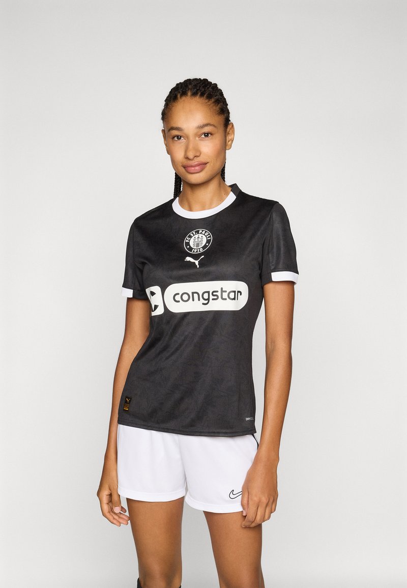 Zwart voetbalshirt met een ronde kraag, witte accenten en logo op de borst, gecombineerd met witte shorts met een Nike-logo.