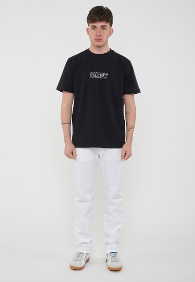 T-shirt nera a maniche corte con logo "BARROW", abbinata a pantaloni bianchi e scarpe con accenti azzurri. Design semplice e casual.
