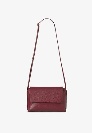 Malá obdélníková kabelka přes rameno z tmavě červené kůže s nastavitelným popruhem a předním klopovým zavíráním.