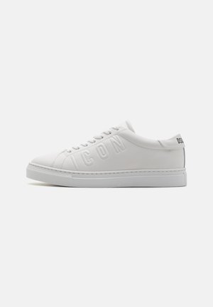 Zapatillas de piel blanca con punta redonda, letras "ICON" en relieve en el lateral y suela de goma texturizada. Diseño minimalista con un acabado suave.