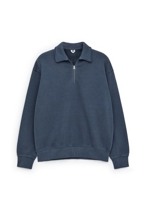 Granatowy sweatshirt z zamkiem błyskawicznym przy kołnierzyku, ściągaczami przy mankietach i u dołu, o miękkiej fakturze i luźnym kroju.