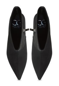 Botines negros con puntera afilada, hechos de un material suave. Cuenta con un cierre de cremallera lateral y un logo en relieve en la plantilla.