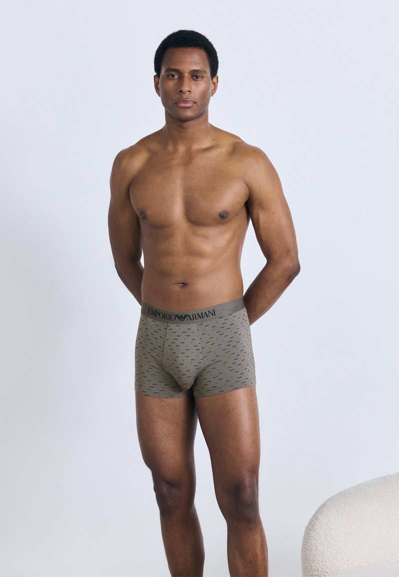 Herren-Boxershorts von Emporio Armani in Olivgrün mit gemustertem Stoff und einem schwarzen, gebrandeten Bund, gefertigt aus weichem, elastischem Material.