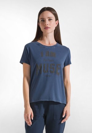 Camiseta de algodón de manga corta en color azul marino, con un audaz texto en negro "SOY MI PROPIO MUSE" en la parte frontal. Cuello redondo clásico, corte relajado.