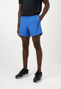 Nike Pro atletiske shorts i livlig blå, med elastisk talje, glat tekstur og en lille sort logoaccent på siden.