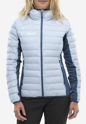 Veste isolée bleu clair avec fermeture éclair à l'avant, panneaux latéraux bleu marine, et col montant. Présente un motif matelassé vertical et un logo sur la poitrine.