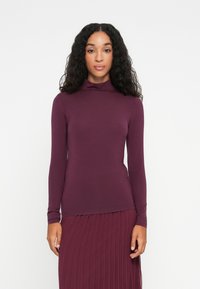 Langermet turtleneck topp i dyp burgunder, laget av myk, elastisk stoff, med en tettsittende passform og minimalt design.