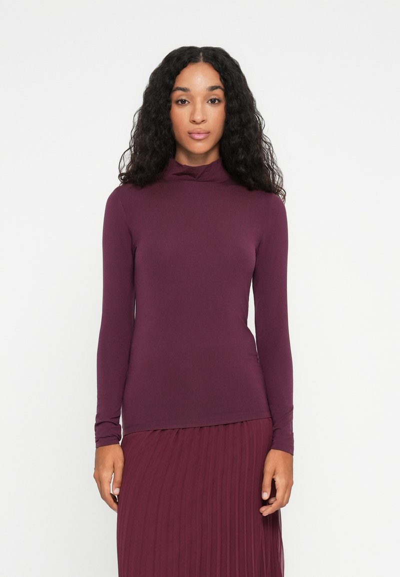 Langermet turtleneck topp i dyp burgunder, laget av myk, elastisk stoff, med en tettsittende passform og minimalt design.