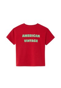 Rode katoenen t-shirt met grote groene letters "AMERICAN VINTAGE" op de achterkant. Korte mouwen en een ronde hals.