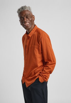 Langermige overhemd met knopen in levendige oranje stof met een zak, gekenmerkt door een relaxte pasvorm en een gladde textuur, gecombineerd met donkere broek.