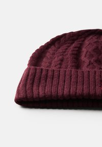 Bordeaux gebreide beanie met geribbelde zoom en kabelbrei-textuur, gemaakt van een zachte wolmix, met een opgevouwen ontwerp.