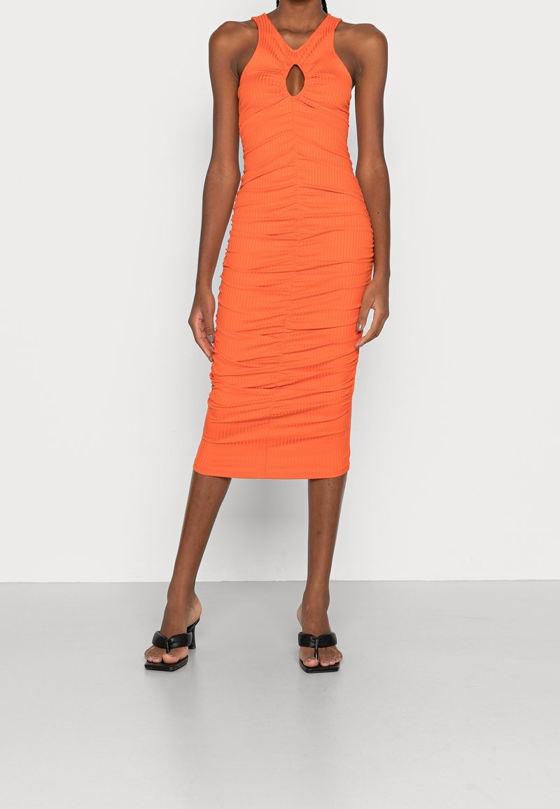 Oranžové žebrované midi šaty s výstřihem ve tvaru klíče, přiléhavého střihu, texturované tkaniny a detailem řasení, doplněné černými sandály na blokovém podpatku.