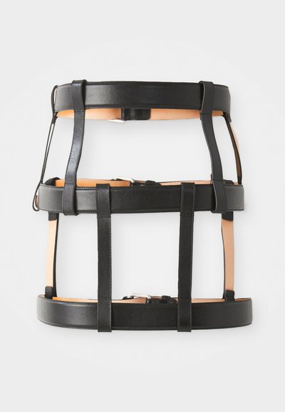 Arnés de cuero negro con acentos de cuero marrón. Presenta múltiples correas y hebillas para un ajuste ajustable. Diseño minimalista y forma estructurada.