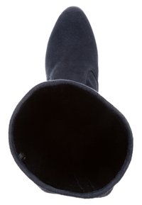 Botín de ante azul marino con puntera puntiaguda y interior suave y texturizado. La caña es lisa con un borde superior redondeado, mostrando un diseño sencillo.