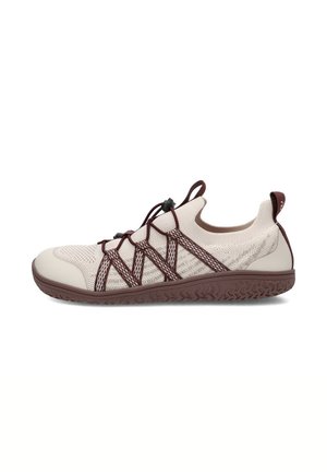 Zapatilla beige de punto tipo slip-on con tiras elásticas cruzadas marrones, lengüetas en el talón y la lengüeta, y suela de goma marrón texturizada.
