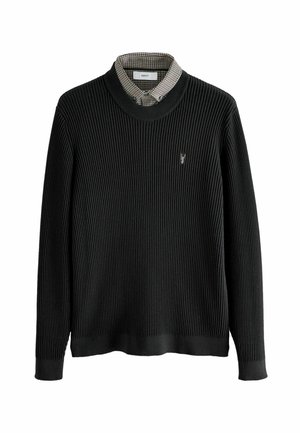 Must mustriba džemper ümmarguse kaela ja pikkade varrukatega. Selle all on ruuduline nööbiga särkide kaelus ja väike logo.