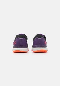 Scarpe da ginnastica viola e nere con tessuto a rete, tacco testurizzato e suola arancione. Presentano un logo sul lato e un design imbottito.