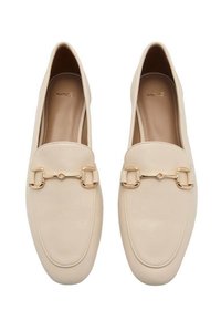 Beige loafers valmistettu sileästä nahasta, jossa on kullanvärinen ketjuakseli edessä ja pyöristetty kärki. Litteä pohja, jossa on hienovarainen ompelu.