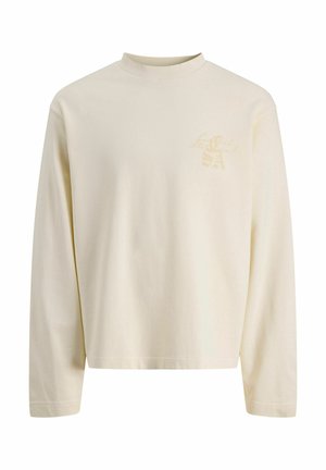 Cream-colored long-sleeve crewneck shirt with subtle beige logo text on the upper left chest, plain front and regular fit.