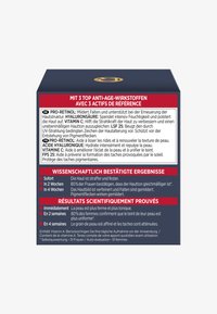 Svart låda med en guldsymbol, innehållande flerspråkig text om anti-aging ingredienser: Pro-Retinol, Hyaluronsyra, Vitamin C och vetenskapliga resultat.