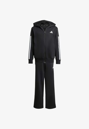 Tuta sportiva nera con giacca a zip con cappuccio, caratterizzata da strisce bianche sulle maniche e logo, abbinata a pantaloni coordinati. Materiale in misto cotone.
