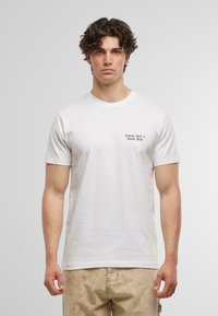 Hvid bomulds t-shirt med korte ærmer, prydet med sort tekst "I dag var en god dag" på venstre bryst. K klassisk pasform, enkel design.