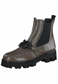 Bottine brillante marron avec des panneaux élastiques sur les côtés, une semelle noire épaisse et un accent décoratif en chaîne noire à l'avant. Fini texturé.