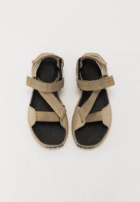 Beige sandals with textured gray straps and black footbed. Features two wide straps and a cushioned sole, designed for comfort and support.