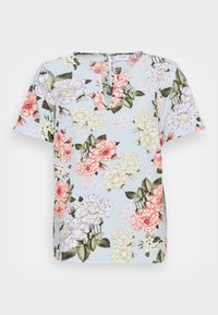 Blouse bleu clair à manches courtes avec un motif floral rose, violet et blanc, et un col en forme de trou de clé avec une fermeture à bouton.
