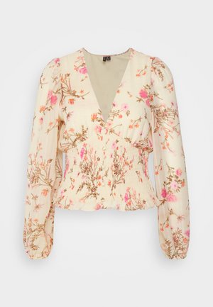 Crèmekleurige blouse met lange mouwen, roze en oranje bloemenprint, diepe V-hals, geplooide taille en pofschouders op een effen achtergrond.