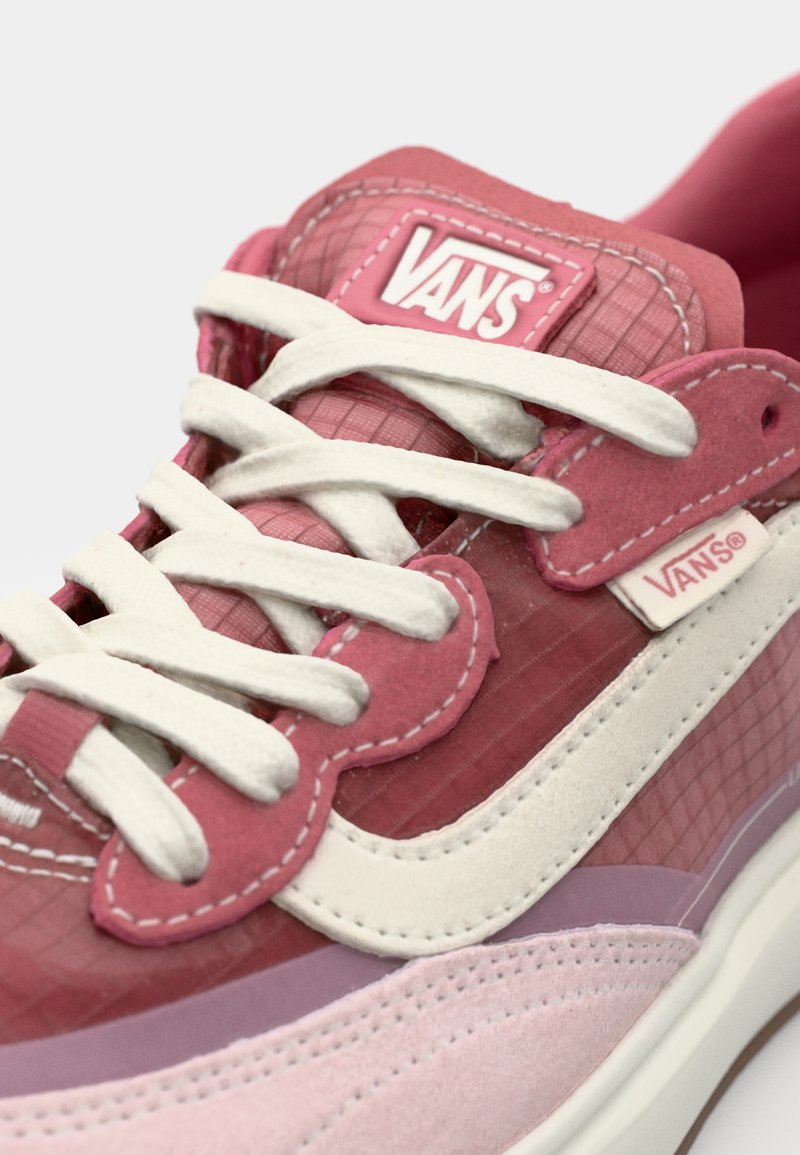 Sneakers Vans in diverse tonalità di rosa, realizzati in materiali scamosciati e tessili, con lacci bianchi e logo distintivo sulla linguetta.