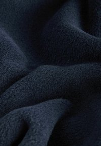 Mørkeblåt fleece stof med en blød, tekstureret overflade, der har bløde folder og en glat, fyldig fornemmelse.