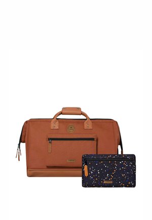 Sac de voyage en cuir marron et tissu avec poche avant et pochette zippée noire tachetée avec des accents orange et bleus.